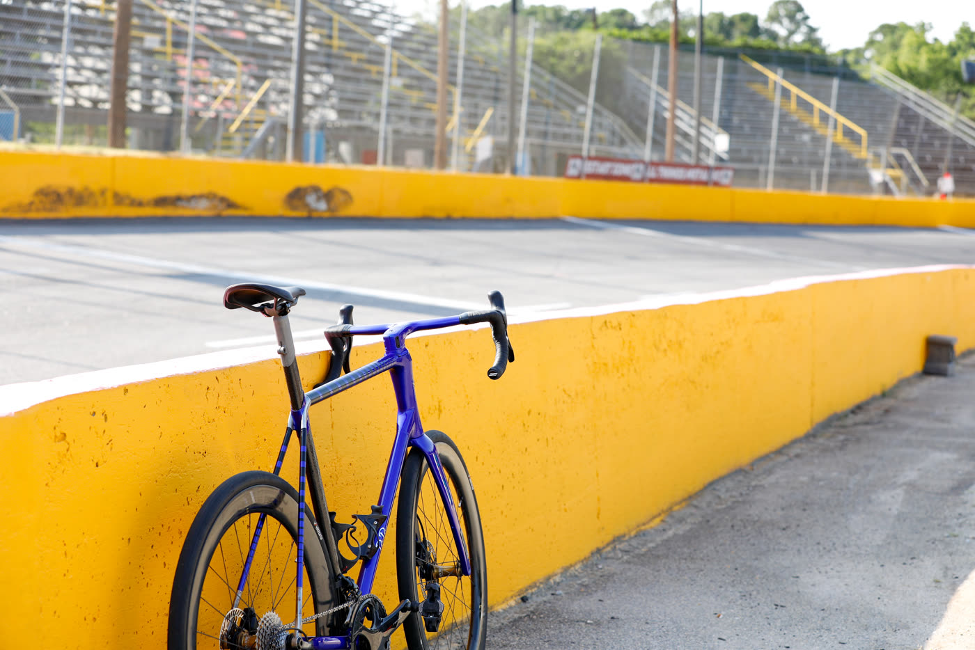 The 427 leaning against the yellow retaining wall at the race track
