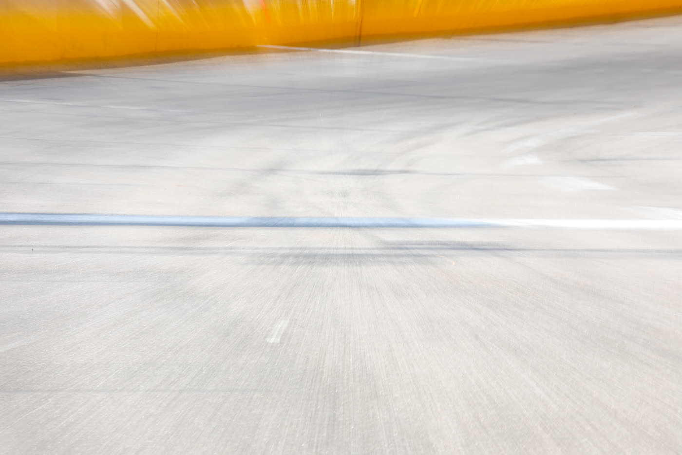 Empty asphalt and the yellow wall - the surface at Wake County Speedway