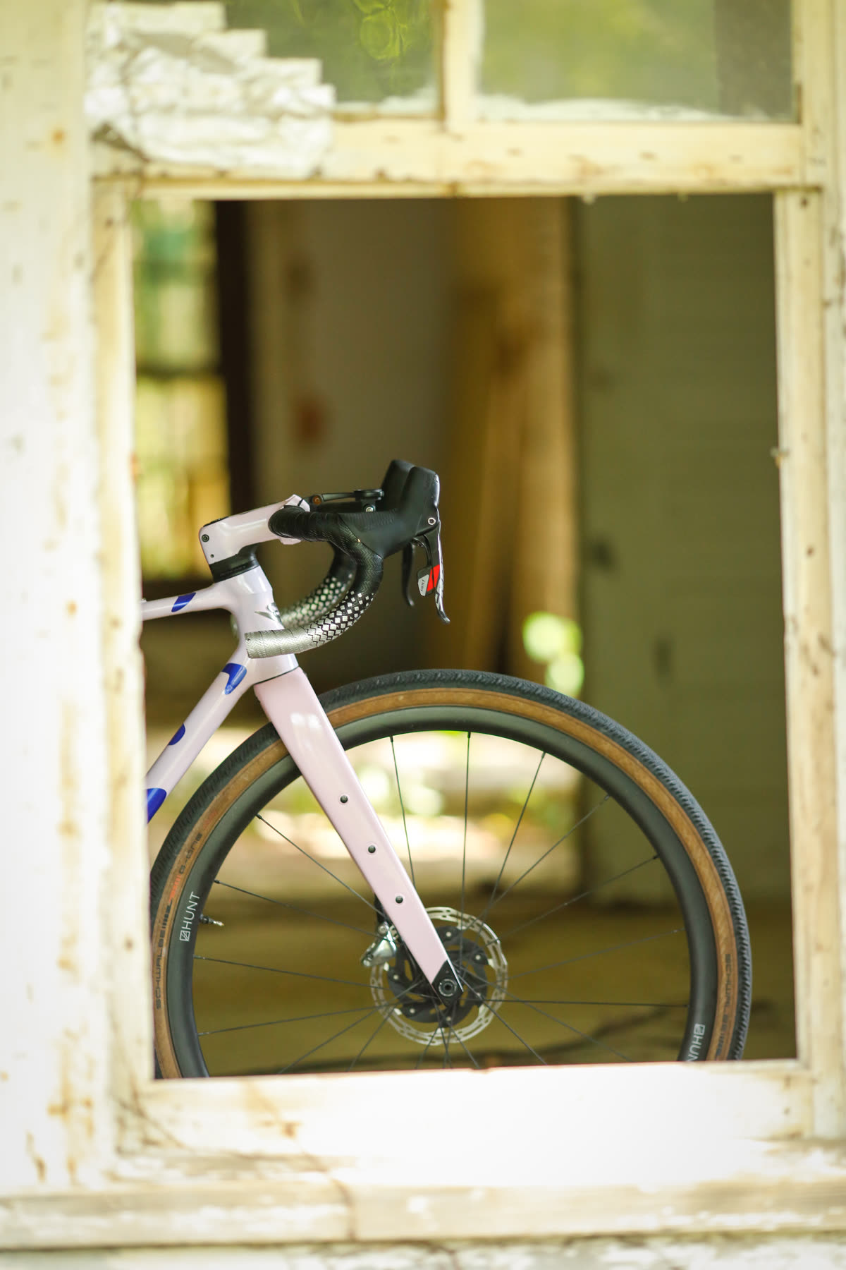 Front fork and gravel tire framed in a weathered old window