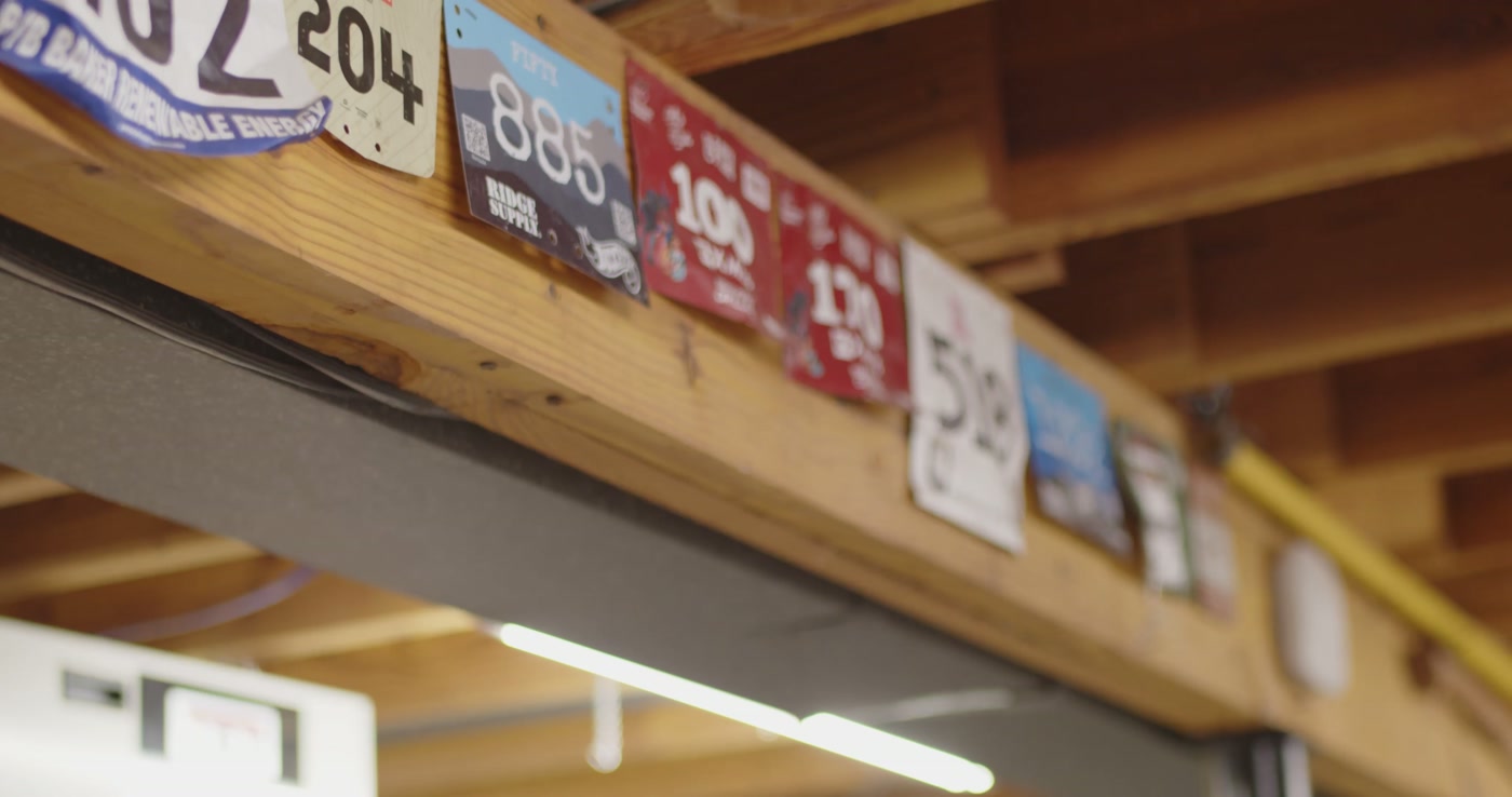 Race number plates lined up on a shelf in the shop